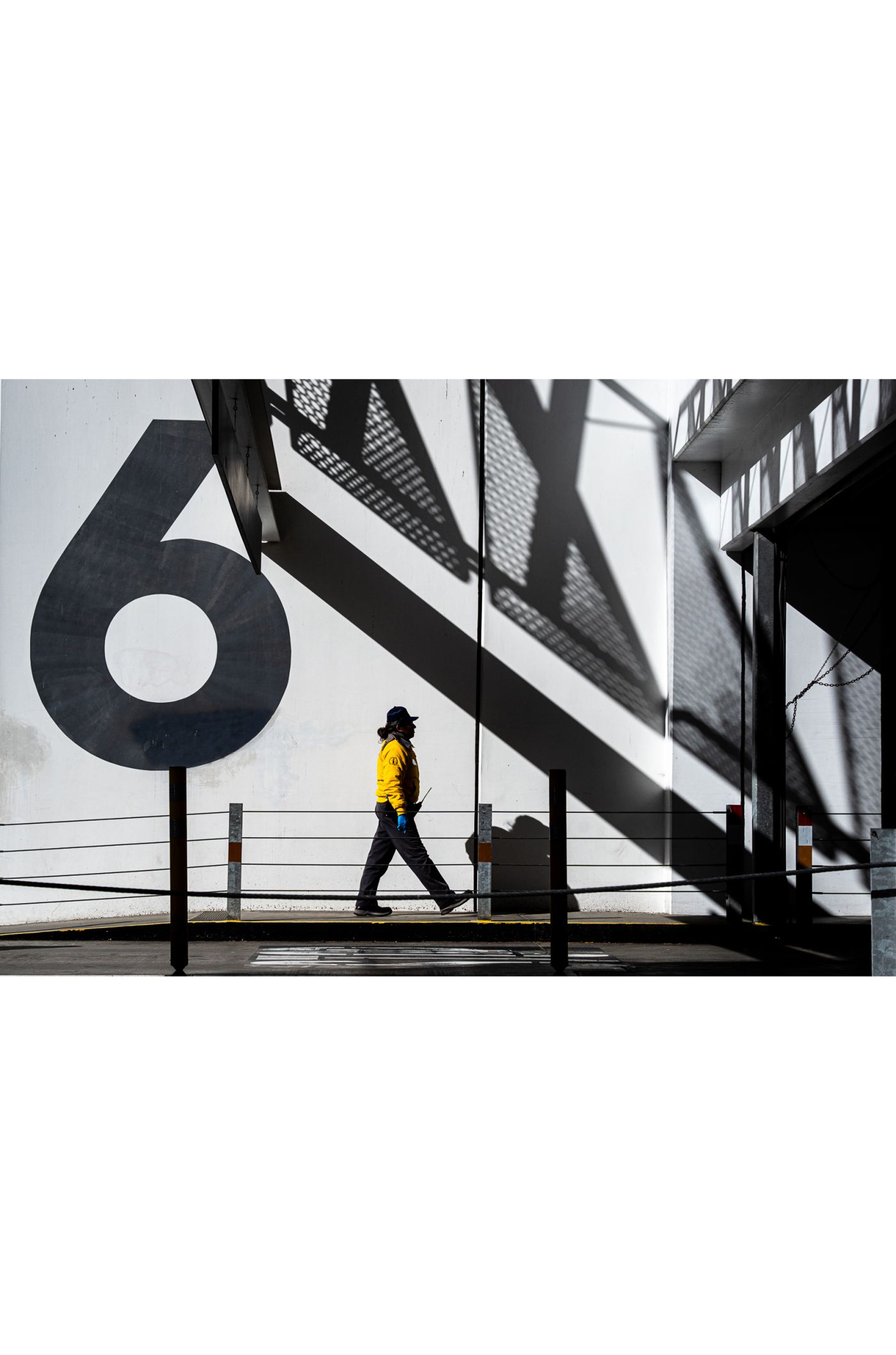 photo of man walking past building 